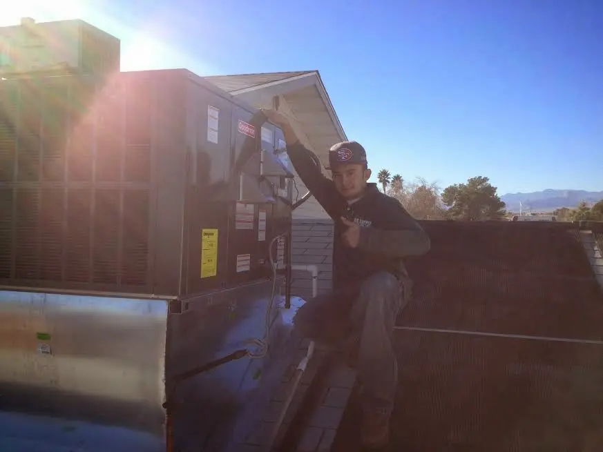 HVAC technician performing AC Tune-Up on a rooftop unit in Manheim